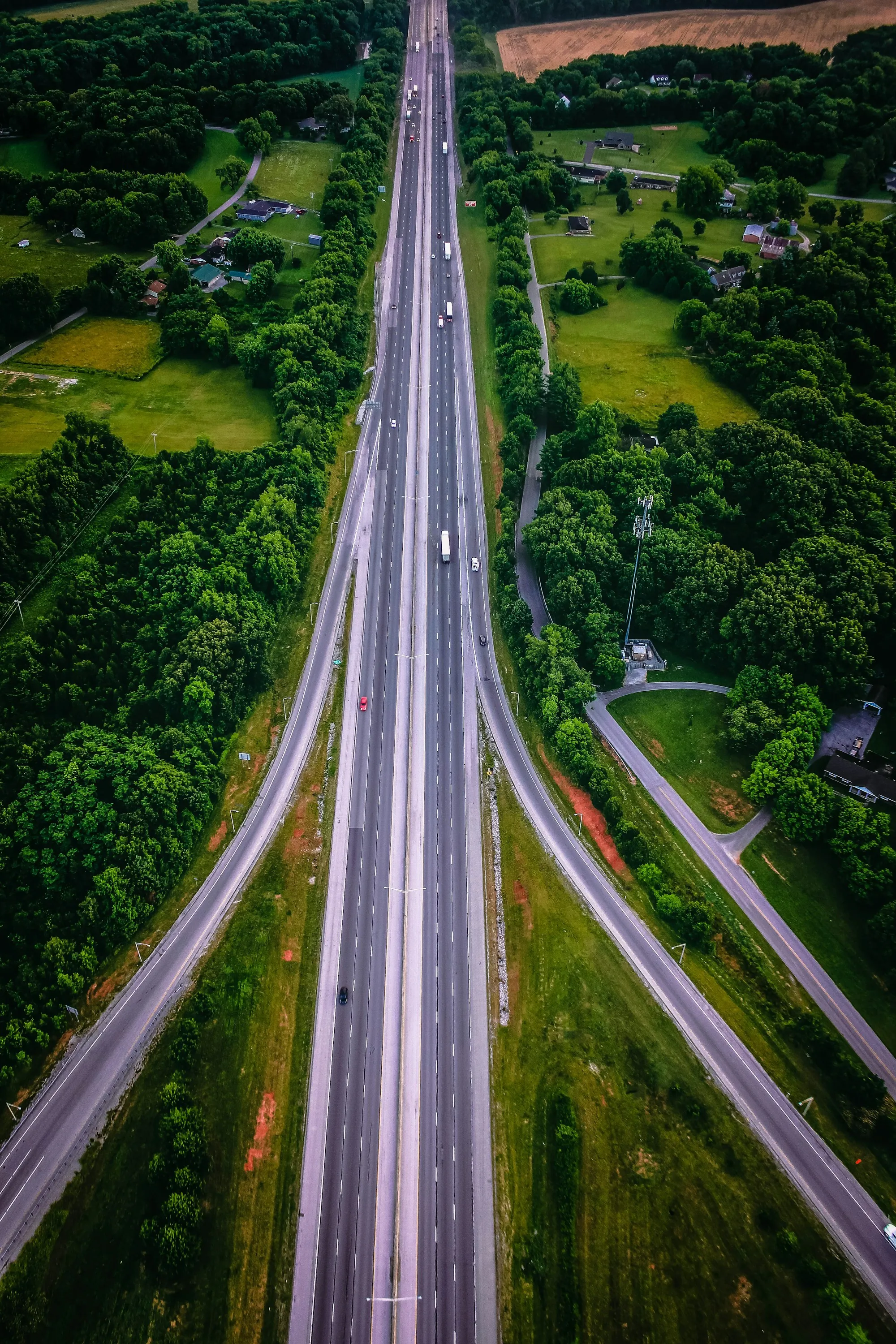 Aerial view of a highway cutting through green woodland